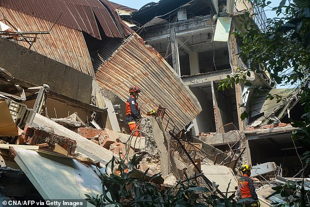 This photo taken by Taiwan's Central News Agency (CNA) on April 3, 2024 shows rescuers searching for survivors trapped in a damaged building in New Taipei City