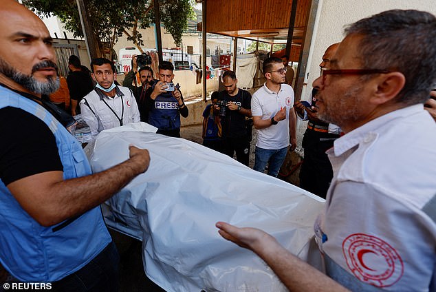 All seven volunteers were killed in three rocket attacks on Monday (photo: people carrying the bodies of one of the volunteers)