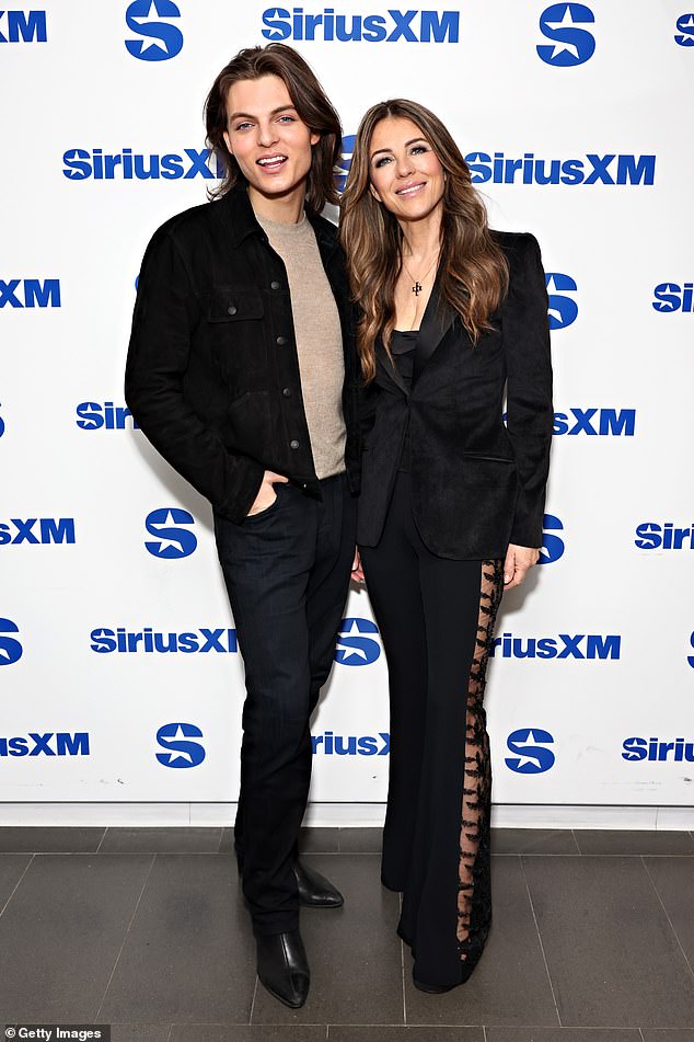 While posing at SiriusXM Studios, Elizabeth looked hot in a black velvet jacket and flared pants with a sheer lace insert on the sides