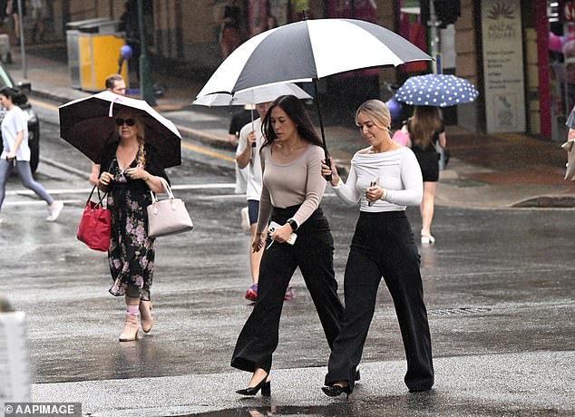 People are seen as rain falls in Brisbane's CBD, Friday, April 5, 2024