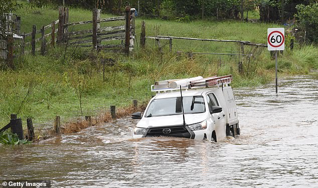 A vehicle attempts to drive through floodwaters in the village of Tintenbar on April 4, 2024 in Byron Bay, Australia