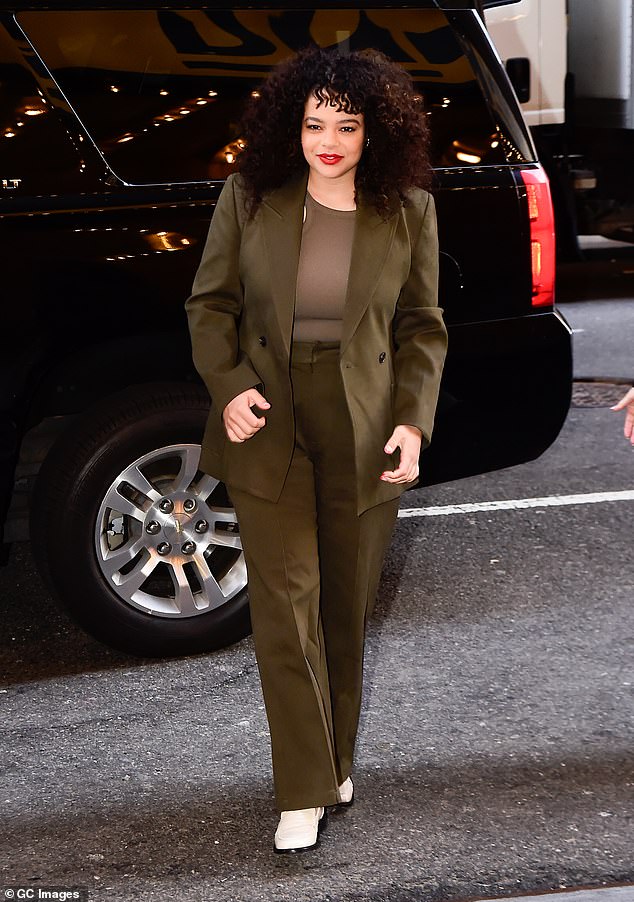 The It's A Sin star wore a loose-fitting khaki suit with a racerneck top underneath