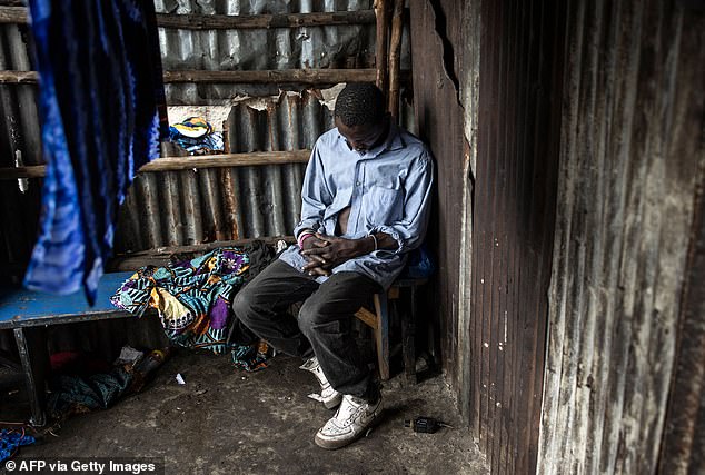 Pictured: A man sleeps in a drug den at the Kington dump in Freetown, in July 2023