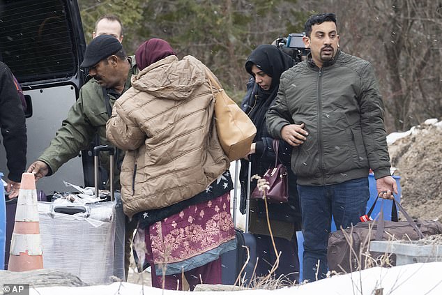 The prime minister, known for his liberal stance on immigration, said the number of temporary migrants in Canada has more than tripled in the past seven years.  (Image: Asylum seekers unload their suitcases from a van as they wait to enter Canada)