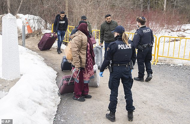 Canadian officers stop asylum seekers as they enter Canada at the Roxham Road entry point into the US