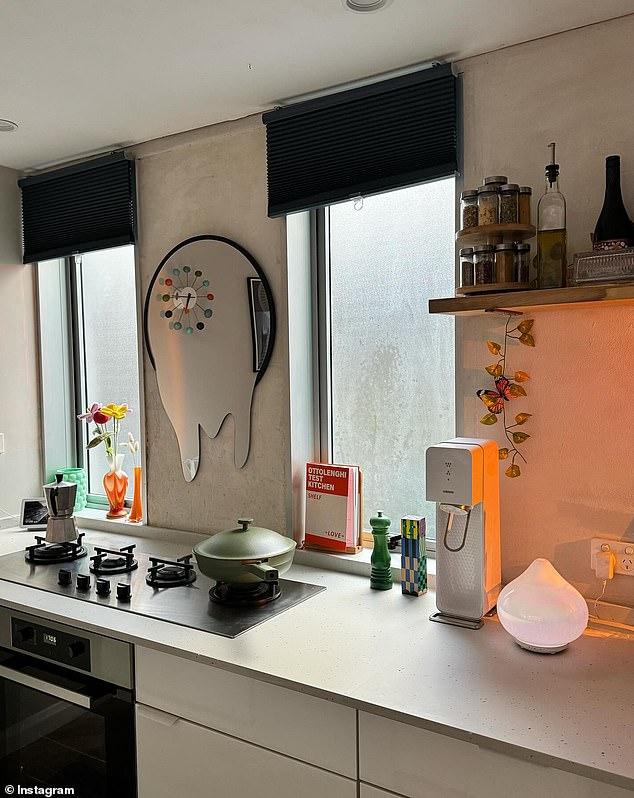 The kitchen is quite simplistic with a 'melting' mirror, vase, cookbooks and diffuser