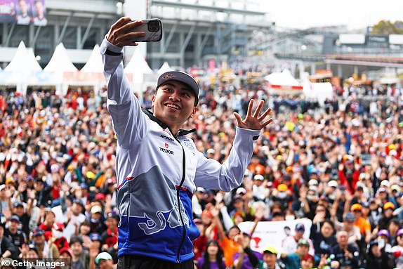 SUZUKA, JAPAN – APRIL 06: Ayumu Iwasa of Japan and Visa Cash App RB take a photo on the fan stage prior to qualifying ahead of the F1 Grand Prix of Japan at Suzuka International Racing Course on April 6, 2024 in Suzuka, Japan.  (Photo by Peter Fox/Getty Images)