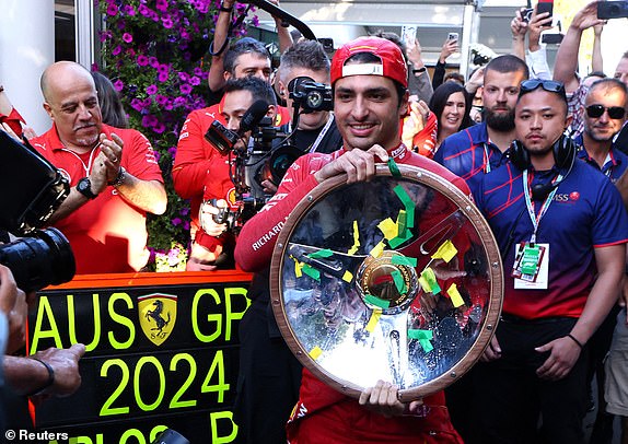 Formula 1 F1 - Australian Grand Prix - Melbourne Grand Prix Circuit, Melbourne, Australia - March 24, 2024 Ferrari's Carlos Sainz Jr.  celebrates with the trophy after winning the Australian Grand Prix REUTERS/Mark Peterson