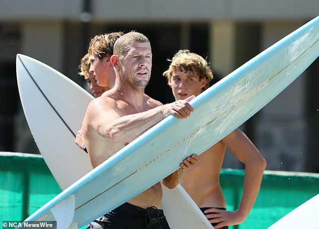 Mick Fanning (front photo) prepares to take to the water in tribute to his late brother Ed