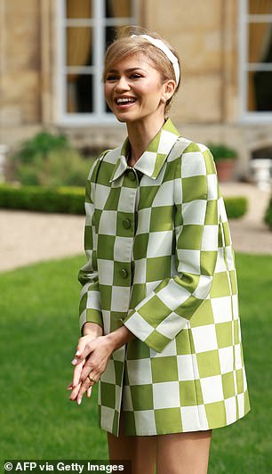 The actress wore a white and green checked jacket with a high collar as she posed in the venue's gardens