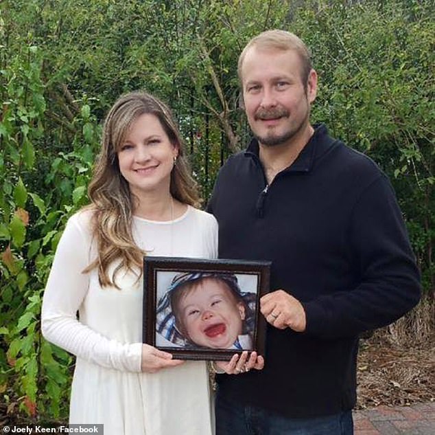 The couple pictured with a photo of their son who died in 2012 when he was just two