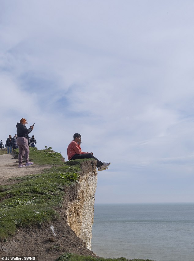 The images were taken by JJ Waller in Birling Gap in East Sussex.  He said: 'Visitors are unaware of how soft the chalk is - and crowds flock to this spot in search of those all-important selfies'