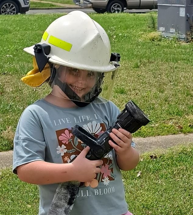 While serving residents in town, she posed for photos with firefighters, who even let her test the hose and wear one of their helmets