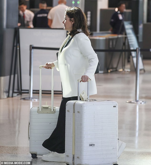 She donned black pants and a matching black top with a white blazer and white sneakers