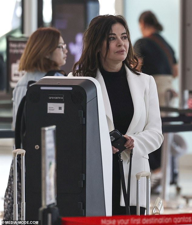 The British television star collected her boarding pass and went to the baggage drop