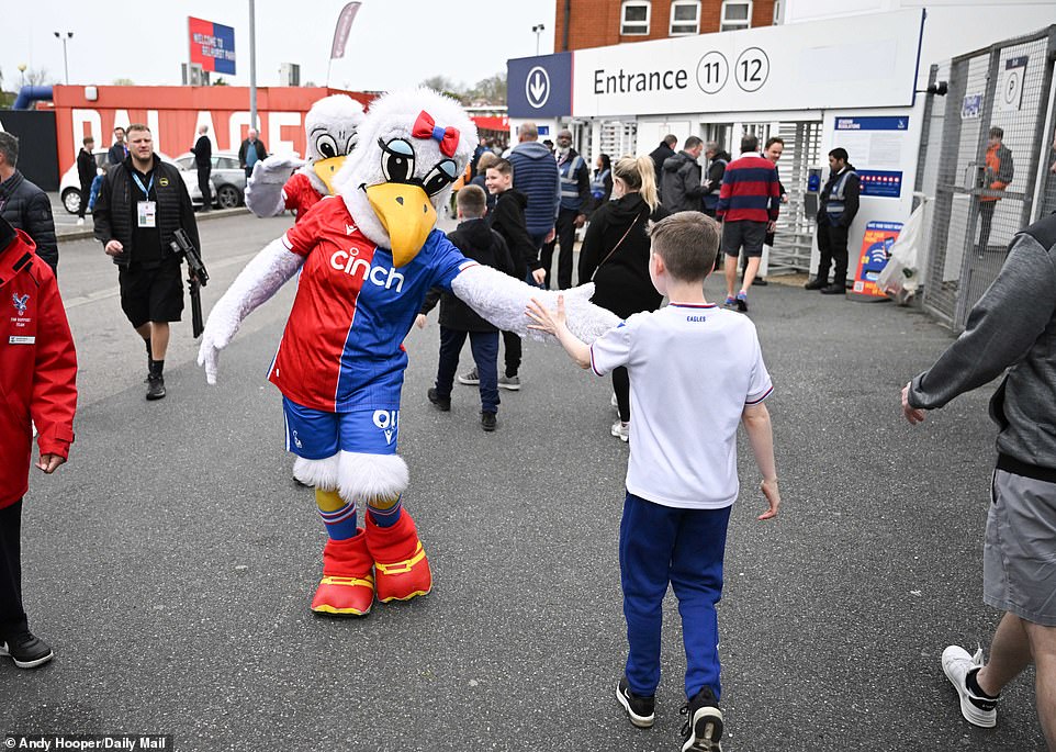 A supporter gave a high five to Palace mascot Alice the Eagle before entering the famous stadium