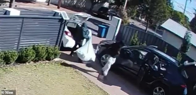 The hooded intruders were seen loading the stolen items into a white car (pictured) before fleeing the scene a short time later
