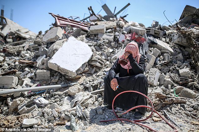 A woman cries on the rubble of a collapsed building after the withdrawal of Israeli troops from Khan Younis, Gaza