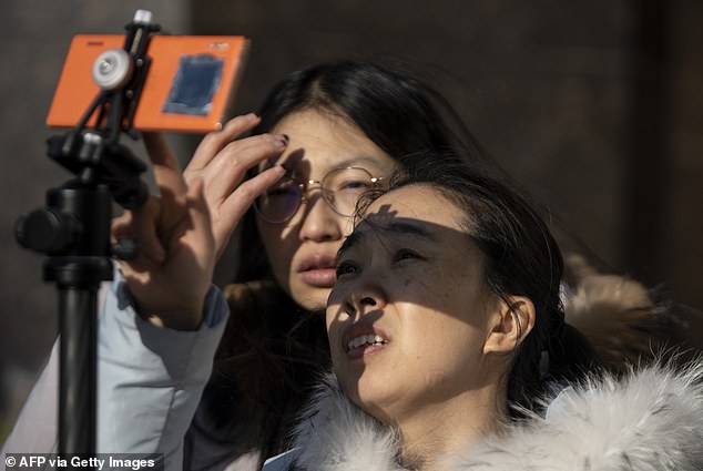 People use a smartphone to look at a rarity 