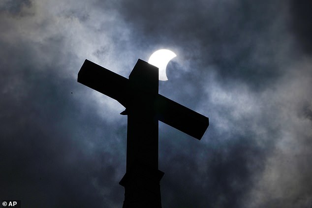 MANOR, TEXAS: Clouds part as a partial solar eclipse passes over a church