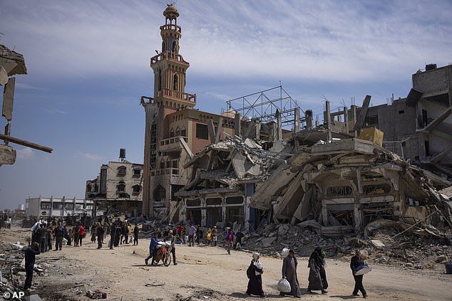 US officials warn of the toll on civilians if the IDF carries out an invasion of Rafah.  Here, Palestinians walk through the destruction in the aftermath of an Israeli air and ground offensive in Khan Younis, southern Gaza Strip, Monday, April 8, 2024