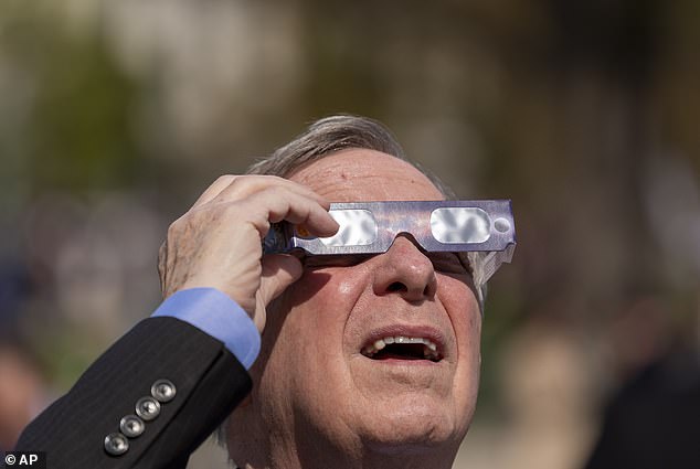 Senator Durbin looks into the sun as he watches the total solar eclipse outside the Capitol