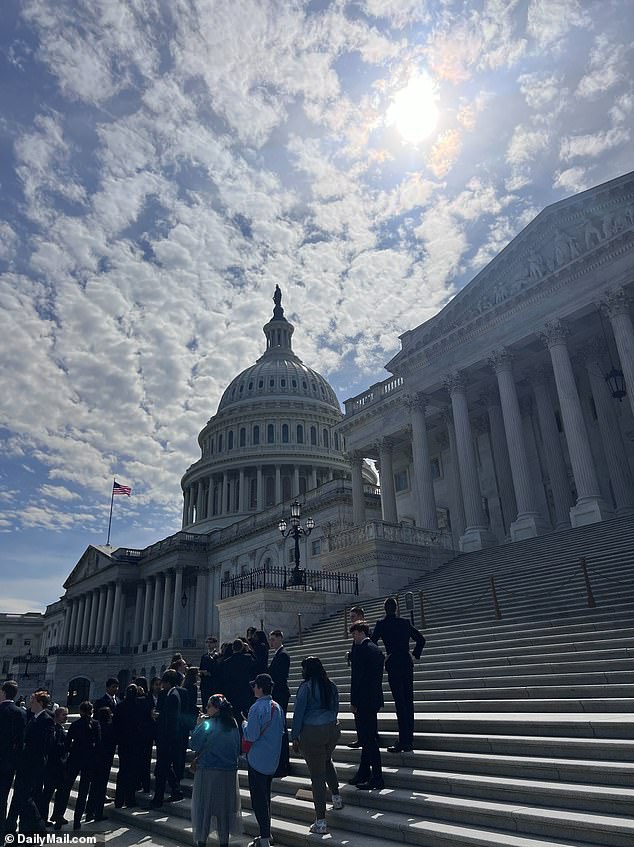 Congressional aides stand on the steps of the Senate and peer into the sun to catch a glimpse of the solar eclipse