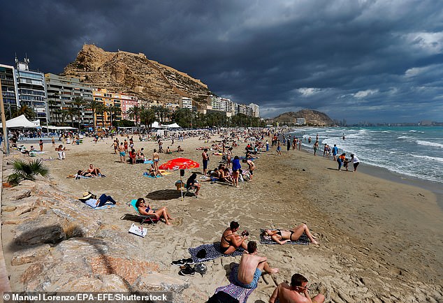 Tourists spend time on Postiguet beach on a cloudy day in the city of Alicante, Comunidad Valenciana region, eastern Spain, March 28, 2024