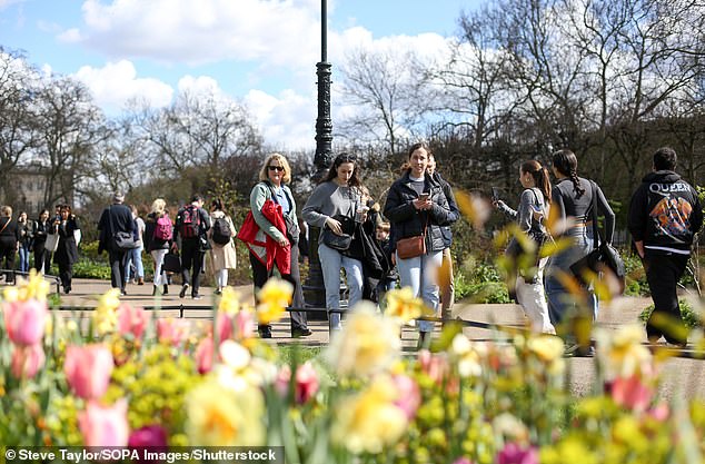 People walk past spring flowers in London's Hyde Park on a sunny spring day, March 30, 2024