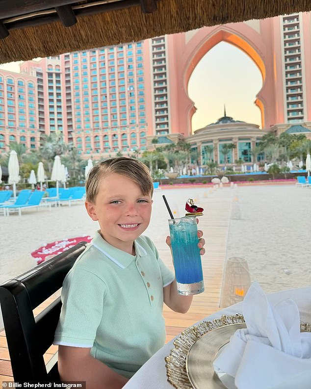 Arthur held up his drink as the family dined together on the beach