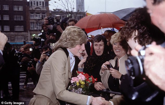 Diana, Princess of Wales, braves wet, stormy weather to meet the crowd waiting for her outside Capital Radio in London, in 1982