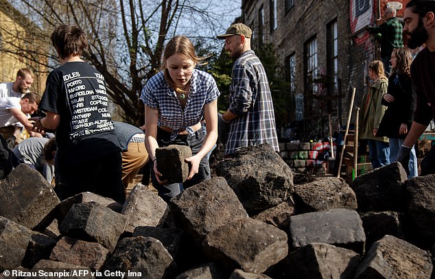 Under the spring sun, local residents got to work with wheelbarrows, shovels and crowbars