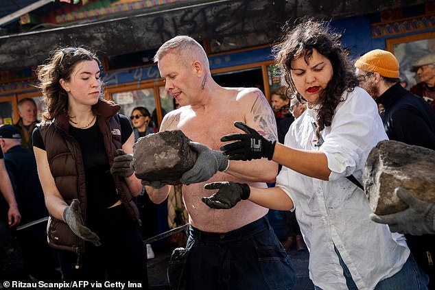 Residents of the Christiania neighborhood pass a cobblestone section dug into Pusher Street