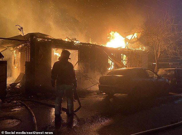 Ukraine launched a massive drone strike on Russia last week, attacking airfields and destroying at least six fighter jets, Kiev said.  Pictured: A man is seen standing next to a burning building in the aftermath of the overnight attacks