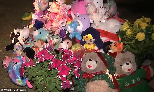 A memorial full of stuffed animals and flowers was erected outside the charred house by friends and family