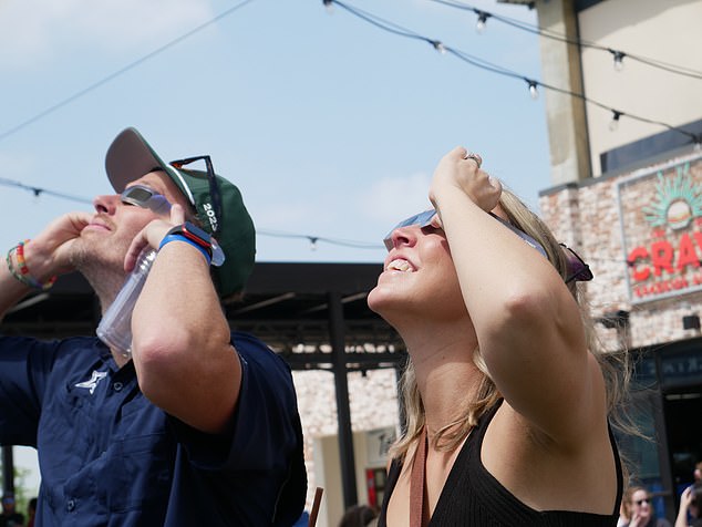 Couples stood side by side to watch the start of the eclipse when excitement erupted and people started clapping as the DJ announced there were only 10 minutes left before totality was reached