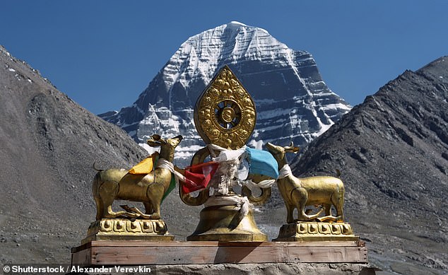 Dharmachakra, the most important Buddhist symbol, on the roof of the Dirapuk Buddhist Monastery, with the north side of Mount Kailash in the background
