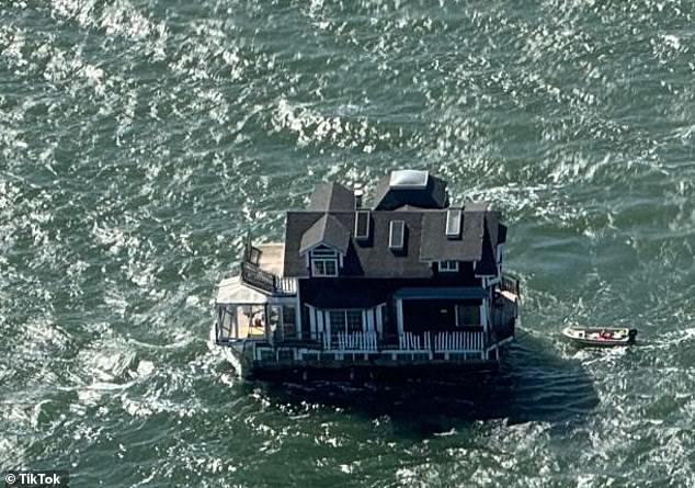 The U.S. Coast Guard oversaw the transfer of the shingled boathouse, which was towed by a smaller boat as it glided through the water across the bay