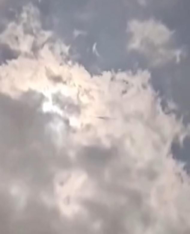 The footage shows glowing clouds hanging in a dark sky while the object appears to be swimming b