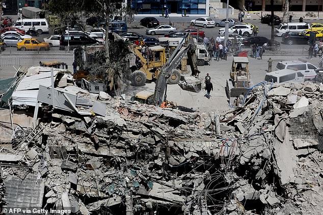 Rescue workers search the rubble of a building belonging to the Iranian embassy a day after an airstrike in Damascus