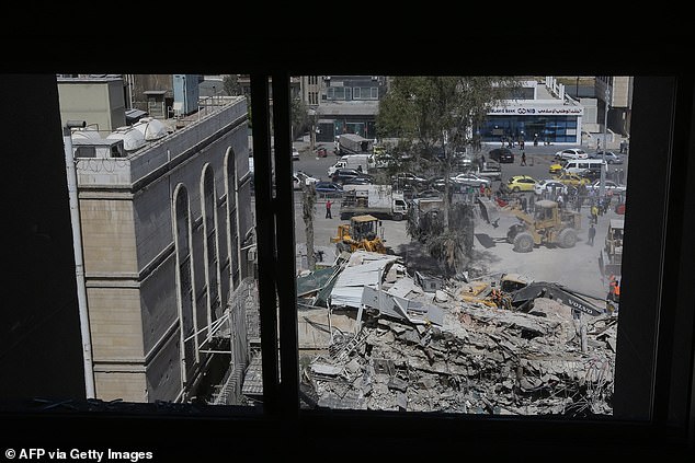 Rescue workers search the rubble of a building belonging to the Iranian embassy a day after an airstrike in Damascus on April 2, 2024