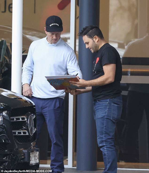 After descending the plane steps, Mark graciously signed his autograph for a waiting fan before driving away in a black vehicle