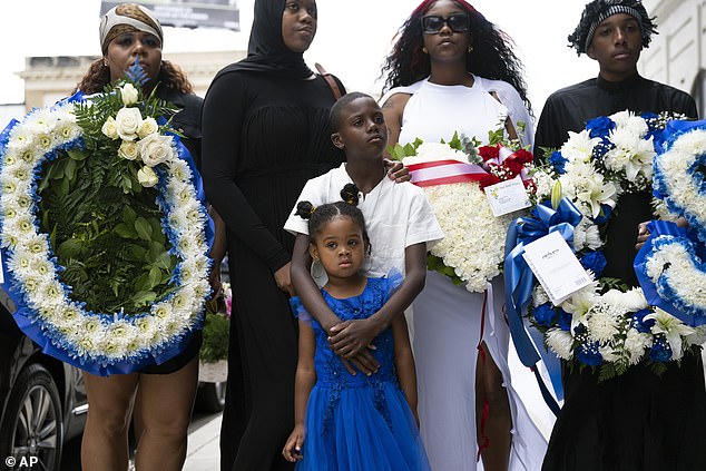 His family, pictured here, is left to mourn the loss of his young life as prosecutors seek justice for his murder