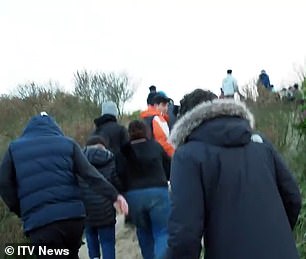 You could see the migrants clambering through the sand dunes