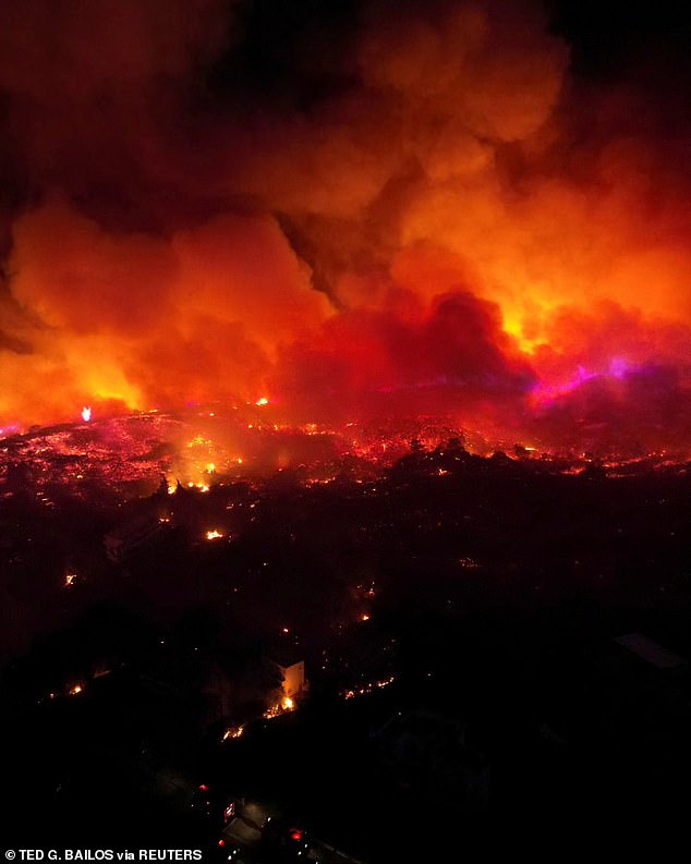 Smoke and flames rise from a bushfire on the island of Rhodes as thousands of Britons flee and head home