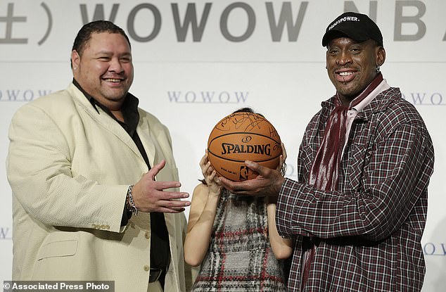 Former NBA basketball player Dennis Rodman, right, former sumo champion Akebono, left, and Japanese actress Maomi Yuki pose for photographers during a press conference to promote a TV show in Tokyo, on October 25, 2013