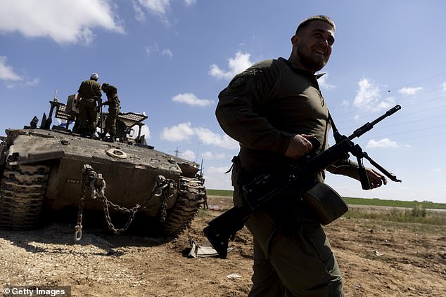 Israeli soldiers prepare their equipment and armored personnel carrier before entering the Gaza Strip on April 10, 2024