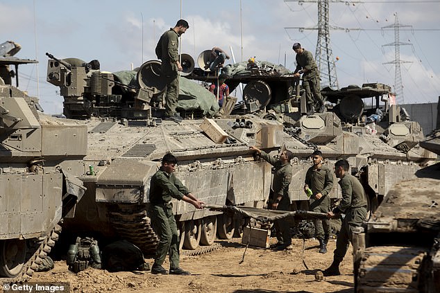 Israeli soldiers prepare their equipment and armored personnel carriers before entering the Gaza Strip on April 10, 2024