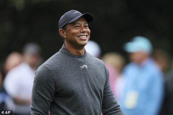 Tiger Woods reacts as he talks to fellow golfers as they walk down the second fairway after their tee shots during a practice round for the Masters golf tournament at Augusta National Golf Club in Augusta, Georgia, Tuesday, April 9, 2024. (Jason Getz/Atlanta Journal-Constitution via AP)