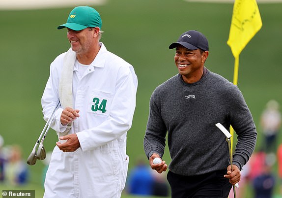 Golf - The Masters - Augusta National Golf Club, Augusta, Georgia, USA - April 9, 2024 Tiger Woods of the USA and his caddy on the green on hole 9 during a practice round REUTERS/Mike Blake